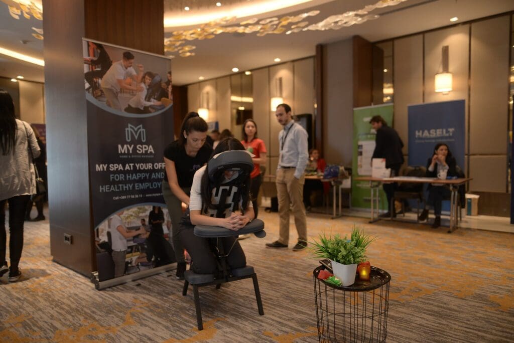 Indoor event massage setup at a conference in Macedonia.