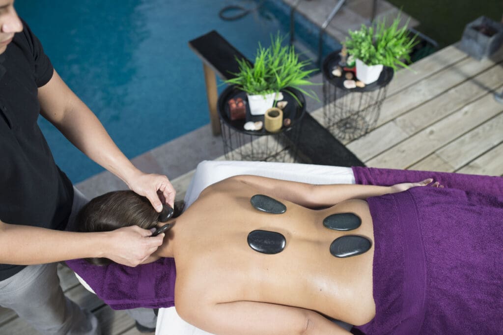 a person getting a hot stone massage at their home.